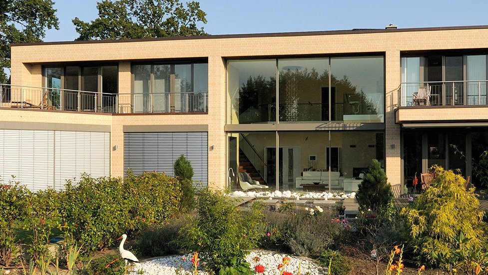 Modernes zweigeschossiges Haus mit großen Glasfronten und Balkon