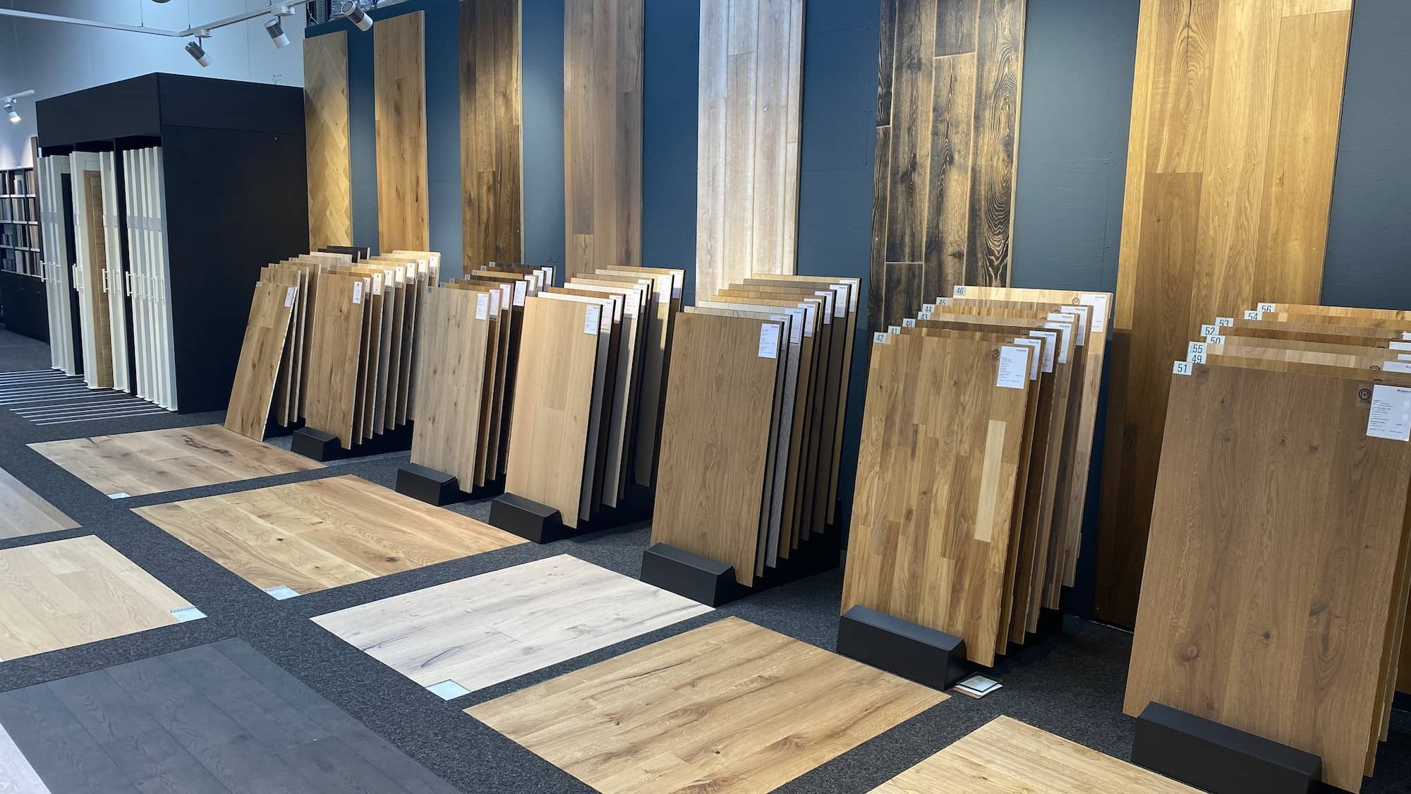 Große Auswahl an stehenden und liegenden Holzbodenmustern im Showroom mit natürlichem Licht