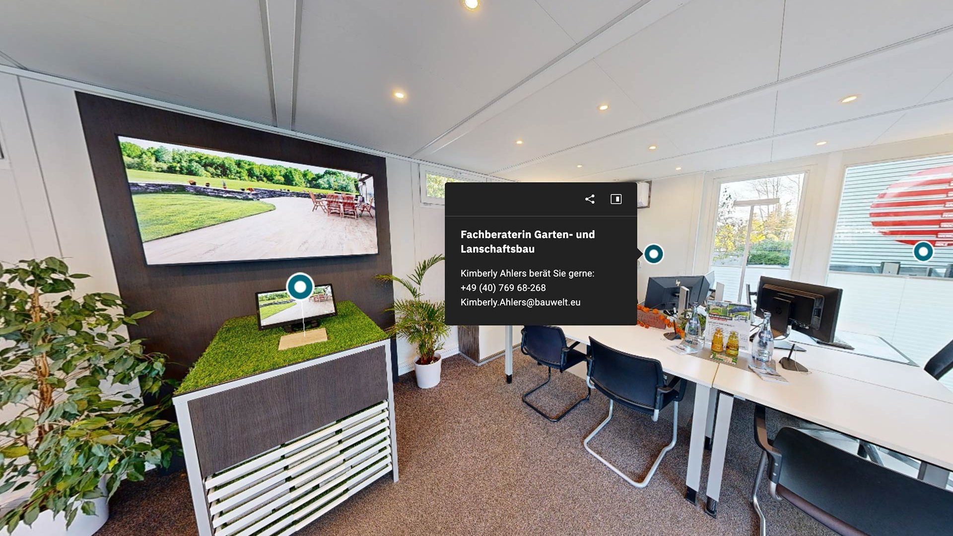 Beratungsraum mit Bürotischen, Pflanzen, einem Monitor und Infotext zu Kimberly Ahlers, Fachberaterin für Garten- und Landschaftsbau