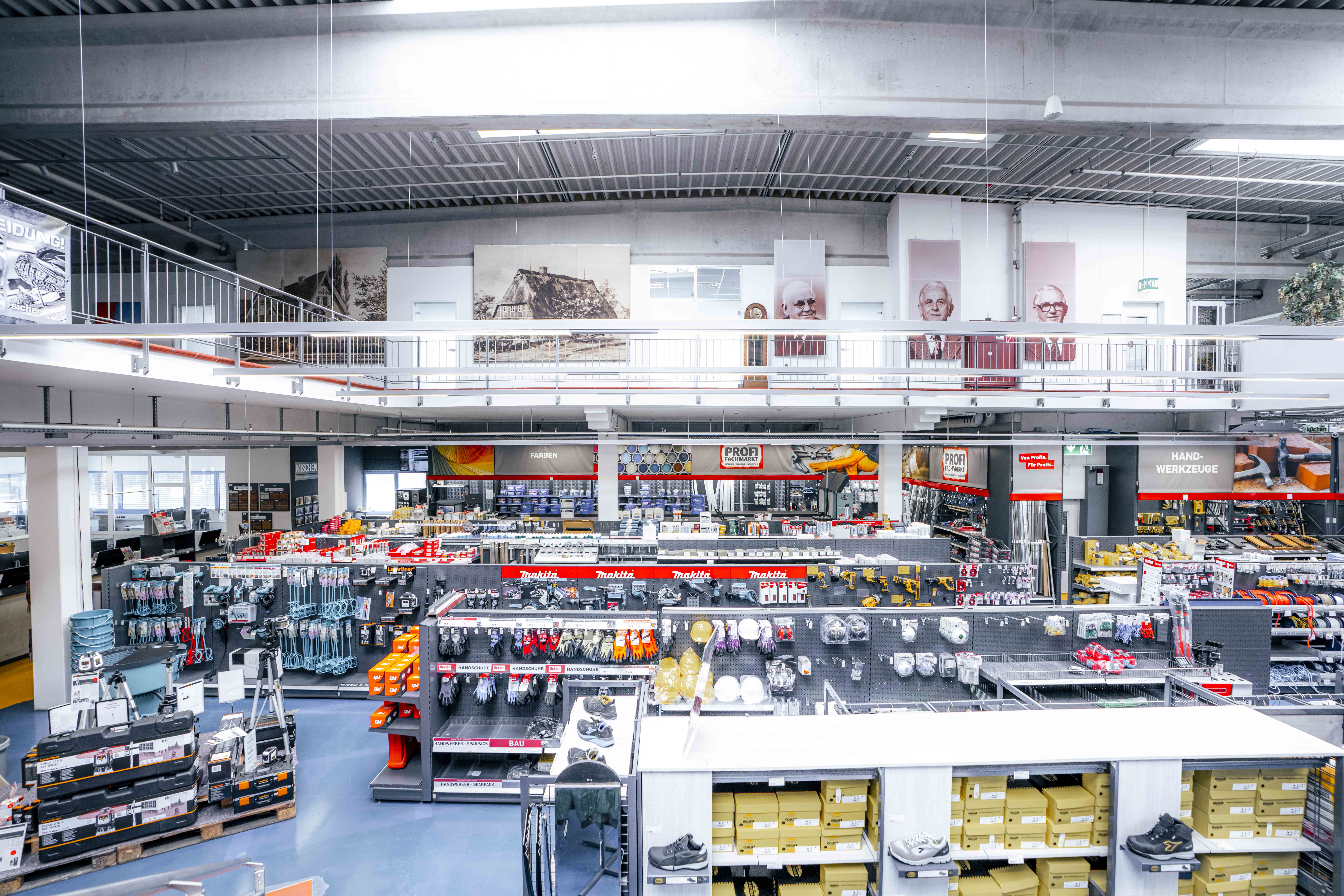 Überblick über die Verkaufsfläche eines Baumarkts mit Regalen voller Werkzeuge, Schutzkleidung, Farben und Zubehör.